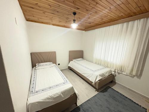 two beds in a room with a window at Liva Kartal in Karasu