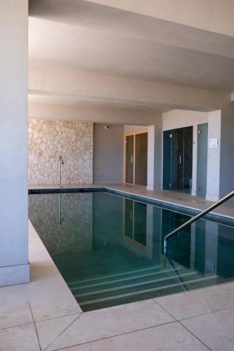 a swimming pool in a building at Hotel Club S'Illot in S'Illot