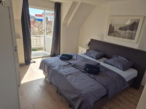 a bedroom with a large bed with blue pillows at Studio At C in Zandvoort