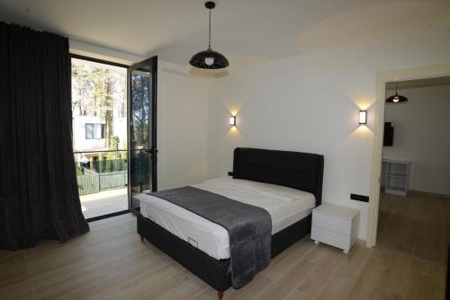 a bedroom with a bed and a large window at Villa White Dolphin Kaprovani in Ureki