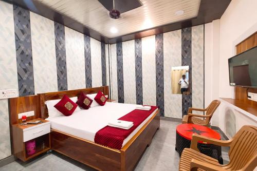 a bedroom with a bed and a chair and a television at Premium-Ram-Krishna-Palace in Ayodhya