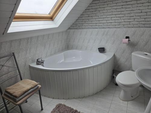 a bathroom with a tub and a toilet and a sink at Jardin Floral in Marquise