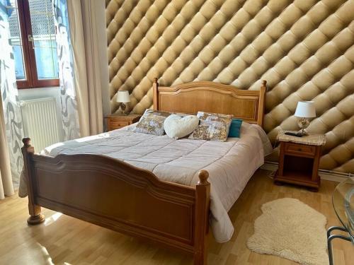 a large padded bedroom with a large bed with pillows at Jardin Floral in Marquise