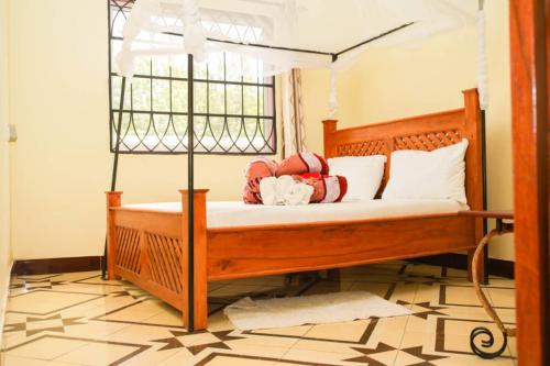 a bedroom with a wooden bed with a canopy at Newfavourlodge in Nkoanrua