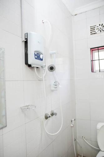 a shower in a white bathroom with a toilet at Newfavourlodge in Nkoanrua