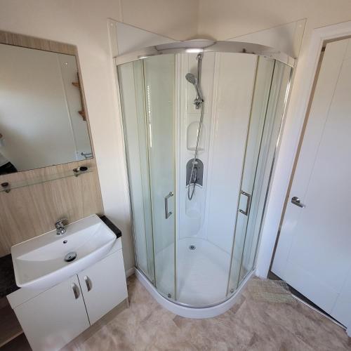 a bathroom with a shower and a sink at Trevella Lakeview Lodge in Newquay