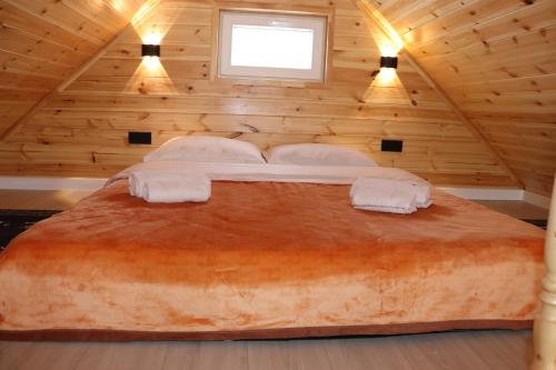 a bedroom with a large bed in a wooden room at Barn Peaks Karakol in Karakol