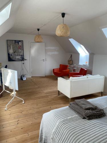 a bedroom with a bed and a living room with a couch at Skøn lejlighed i centrum in Herning