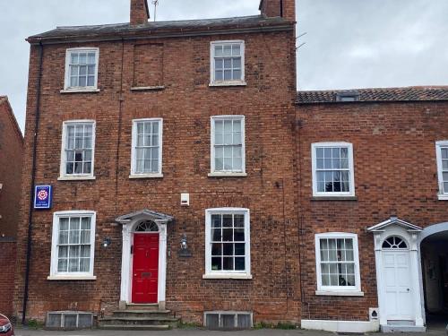an old red brick building with a red door at The Red House Guest House in Grantham