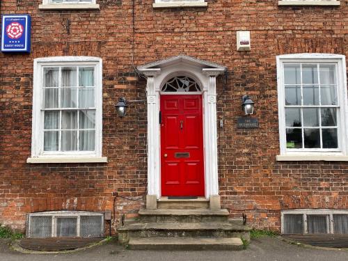 a red door on the side of a brick building at The Red House Guest House in Grantham
