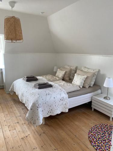 a white bedroom with a bed with a white blanket at Skøn lejlighed i centrum in Herning