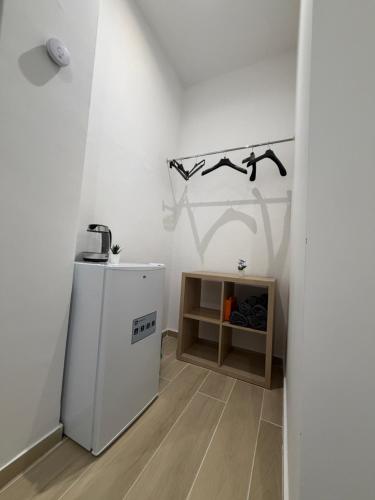 a white room with a refrigerator and a shelf at Heart Of Bari in Bari