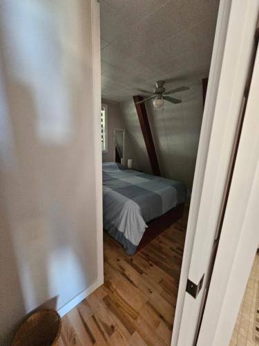 ein Schlafzimmer mit einem Bett und einer Decke in der Unterkunft Chalet le Léandre in Cabano