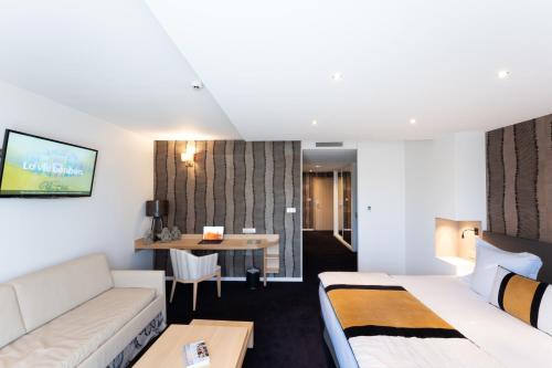 a hotel room with a bed and a desk at Le Konine - Hotel & Bar & Restaurant in Montceau-les-Mines