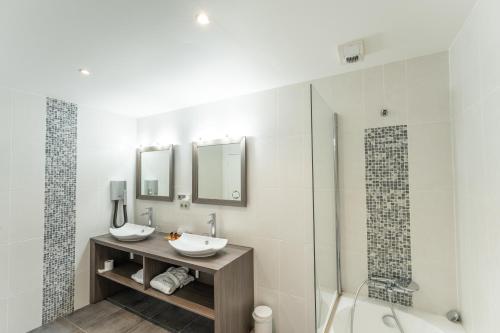 a bathroom with two sinks and a shower at Le Konine - Hotel & Bar & Restaurant in Montceau-les-Mines