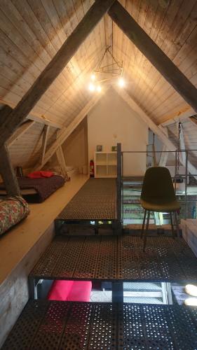 a room with a bed and a chair in a attic at Loft ça suffit, Eddy! in Zingem