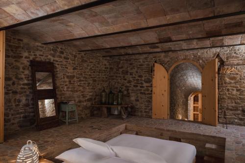a room with a white bed in a brick wall at Castello di Granarola Relais - Adults Friendly - in Gradara