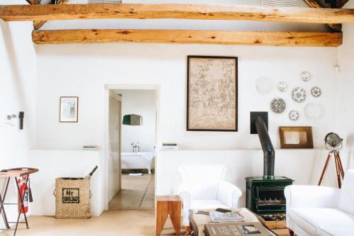 ein Wohnzimmer mit weißen Wänden und Holzbalken in der Unterkunft Babylonstoren in Simondium