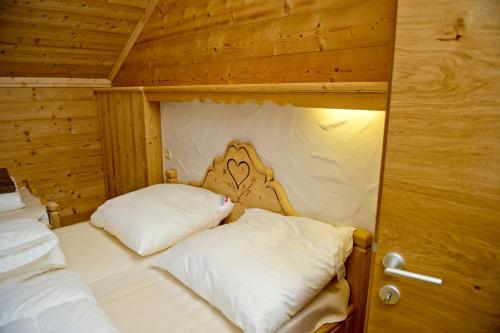 a bedroom with two beds in a wooden cabin at Ferienhäuser Tschofen Garfrescha in Sankt Gallenkirch