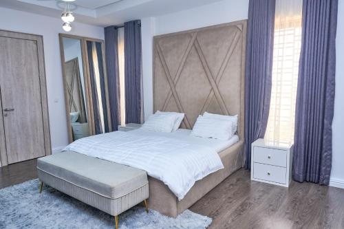 a bedroom with a large bed with a large headboard at Jimi Comfort Stay in Bamgbose