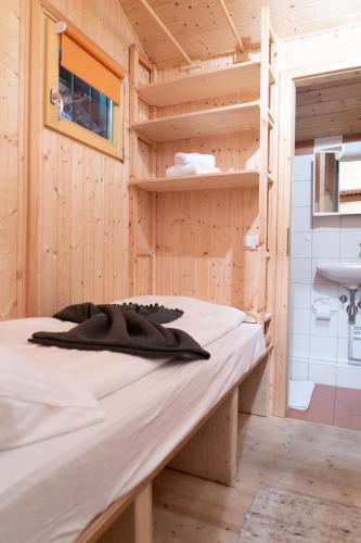 a bed in a tiny house with a sink at Romantisches Berg-Chalet in Bayrischzell
