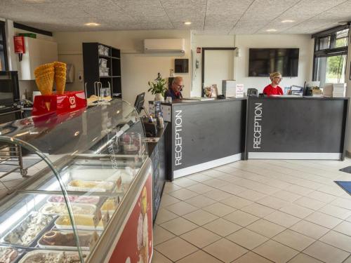 a fast food restaurant with two people sitting at the counter at DCU-Camping Ålbæk Strand in Ålbæk