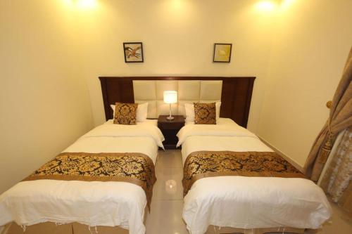 two beds in a hotel room with a bedsenalsenalsenalsenalsenalsenalangering at Lara Al Jawf Hotel Apartments in Arar