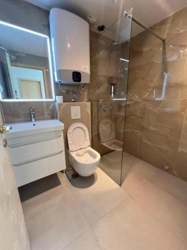a bathroom with a toilet and a sink and a shower at Central nude oasis in Makarska