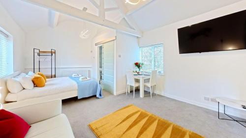 a living room with a bed and a tv at The Saddlery in Sewerby