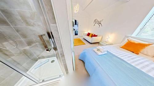 a bathroom with a shower and a bed in a room at The Saddlery in Sewerby