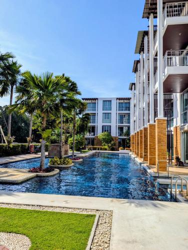 a swimming pool in front of a building at Vimanlay 84m style balinais - 2 chambres - plage, piscines in Cha Am