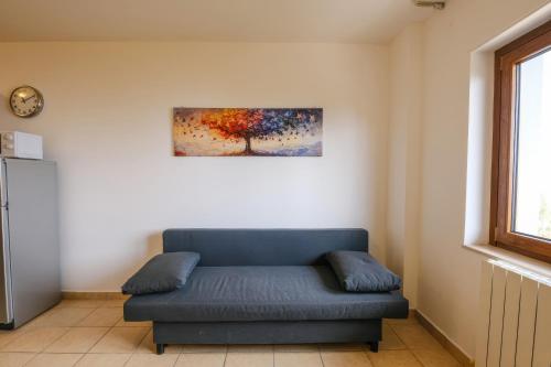 a blue couch in a room with a painting on the wall at Vista Mare in Sassonetto