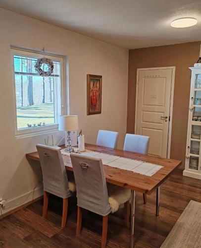 a dining room with a wooden table and chairs at Villa Tammikallio Guest House, near the airport - Kodikas vierasmaja Tuusulassa in Tuusula