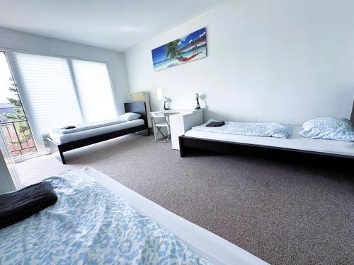 a bedroom with two beds and a desk and a window at ROOMS Vystaviste BVV in Brno