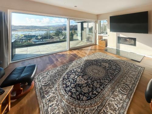 a living room with a large window and a large rug at Grey Rocks House in Kippford