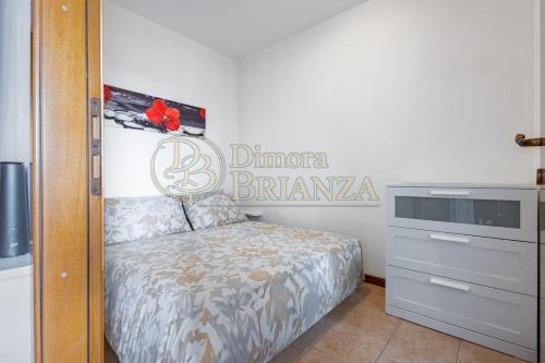 a bedroom with a bed and a sign on the wall at LT Dimora Brianza in Bovísio-Masciago Milanese