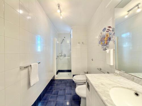 a white bathroom with a toilet and a sink at VILLA MARE BLU in Levanto