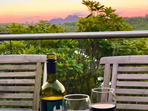 a bottle of wine sitting on a table with two glasses at Summit in Oban