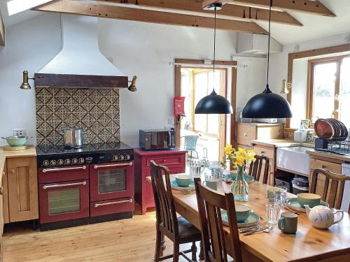 a kitchen with a wooden table and a stove top oven at Juniper Cottage in Buckie