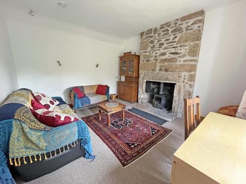 a living room with a couch and a fireplace at Juniper Cottage in Buckie