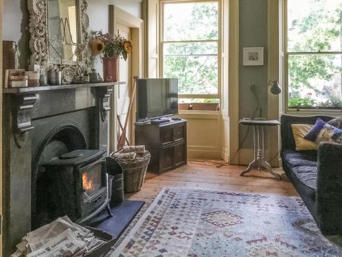 a living room with a fireplace and a tv at Campbells Stables in Berwick-Upon-Tweed