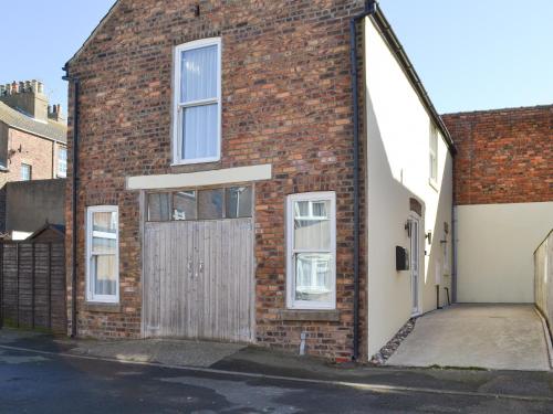 a brick building with a wooden door on it at The Bait Shed in Filey