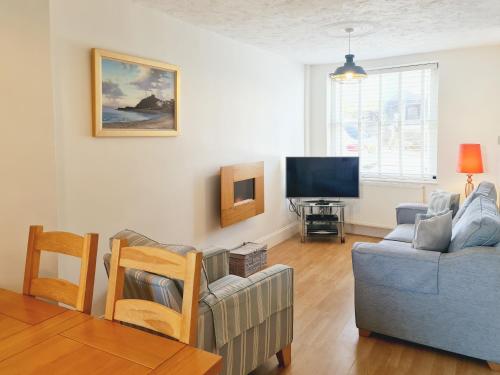 a living room with a couch and a tv at Castle Street in Criccieth