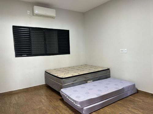 two mattresses in a room with a window at Rancho Vida Boa em Miguelopolis in Miguelópolis