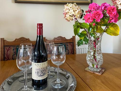 a bottle of wine sitting on a table with wine glasses at Aldersyde in Tighnabruaich