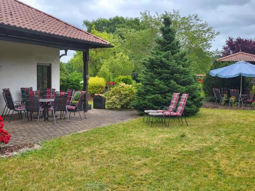 a patio with chairs and a table and an umbrella at Ferienhaus Am Sonnenhang in Zerf