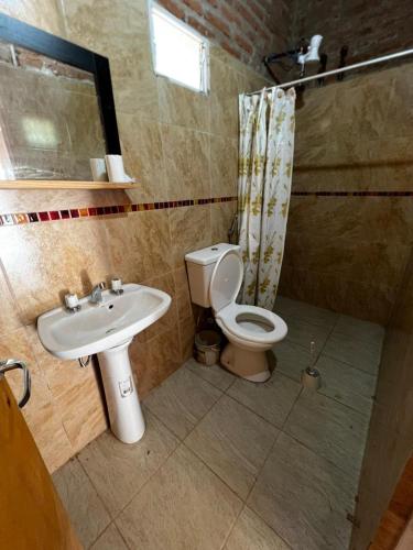 a bathroom with a toilet and a sink at Quincho El Milagro in Camba Punta