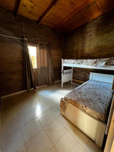 a bedroom with a bed in a wooden room at Quincho El Milagro in Camba Punta