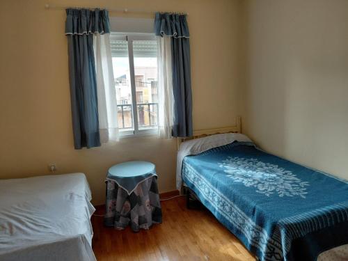 a bedroom with two beds and a window at Alojamiento Rural - El Rocin in Elche de la Sierra