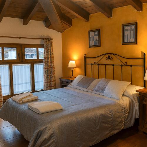a bedroom with a large bed with two towels on it at APARTAMENTOS MARIAJE in Barro de Llanes